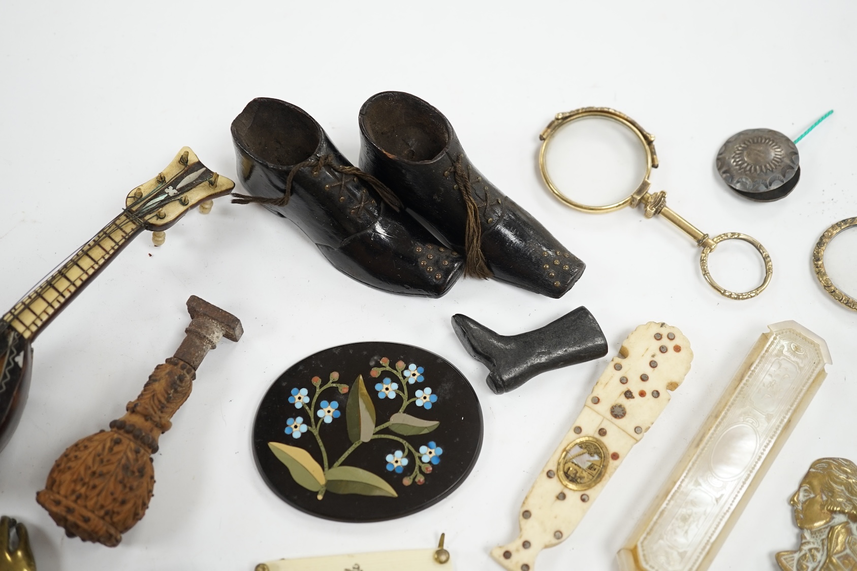 Miscellaneous objects of vertu including a pair of carved wood boots, an inlaid tortoiseshell needle case, a carved mother of pearl box and a pietra dura oval floral panel, largest 12.5cm in length. Condition - mostly fa